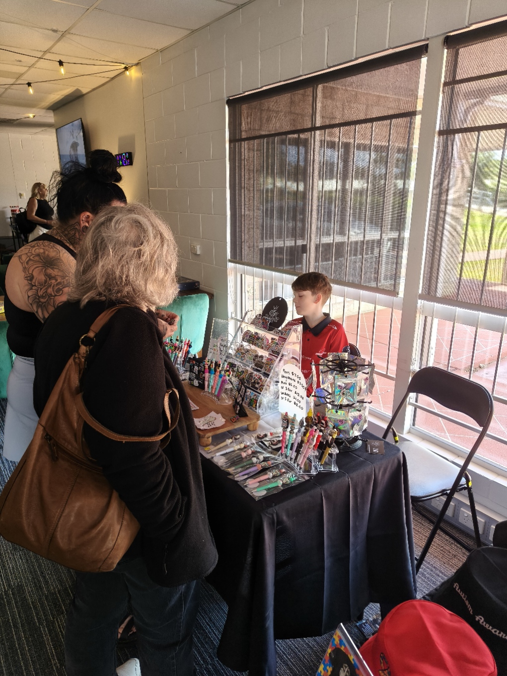 A young vendor tending his market stall of pens, keychains and stickers at The Pulse Open Day